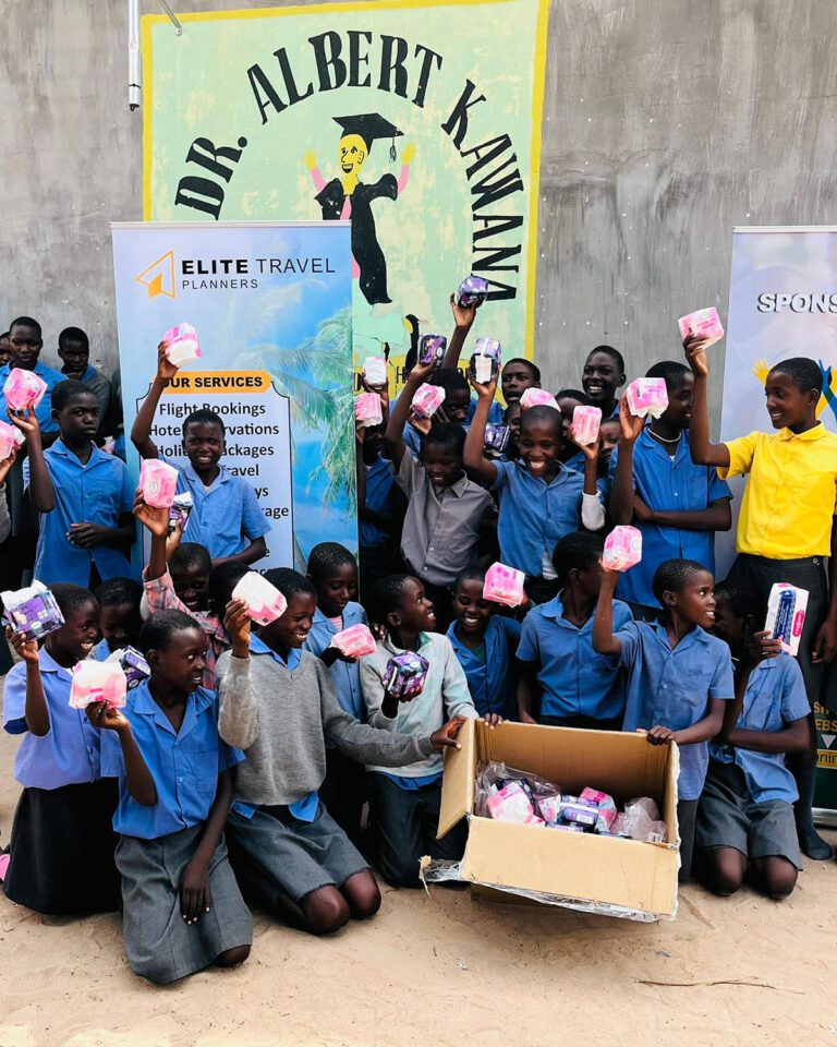 Namibian students happily display donated sanitary pads during a distribution event sponsored by Elite Travel Planners.